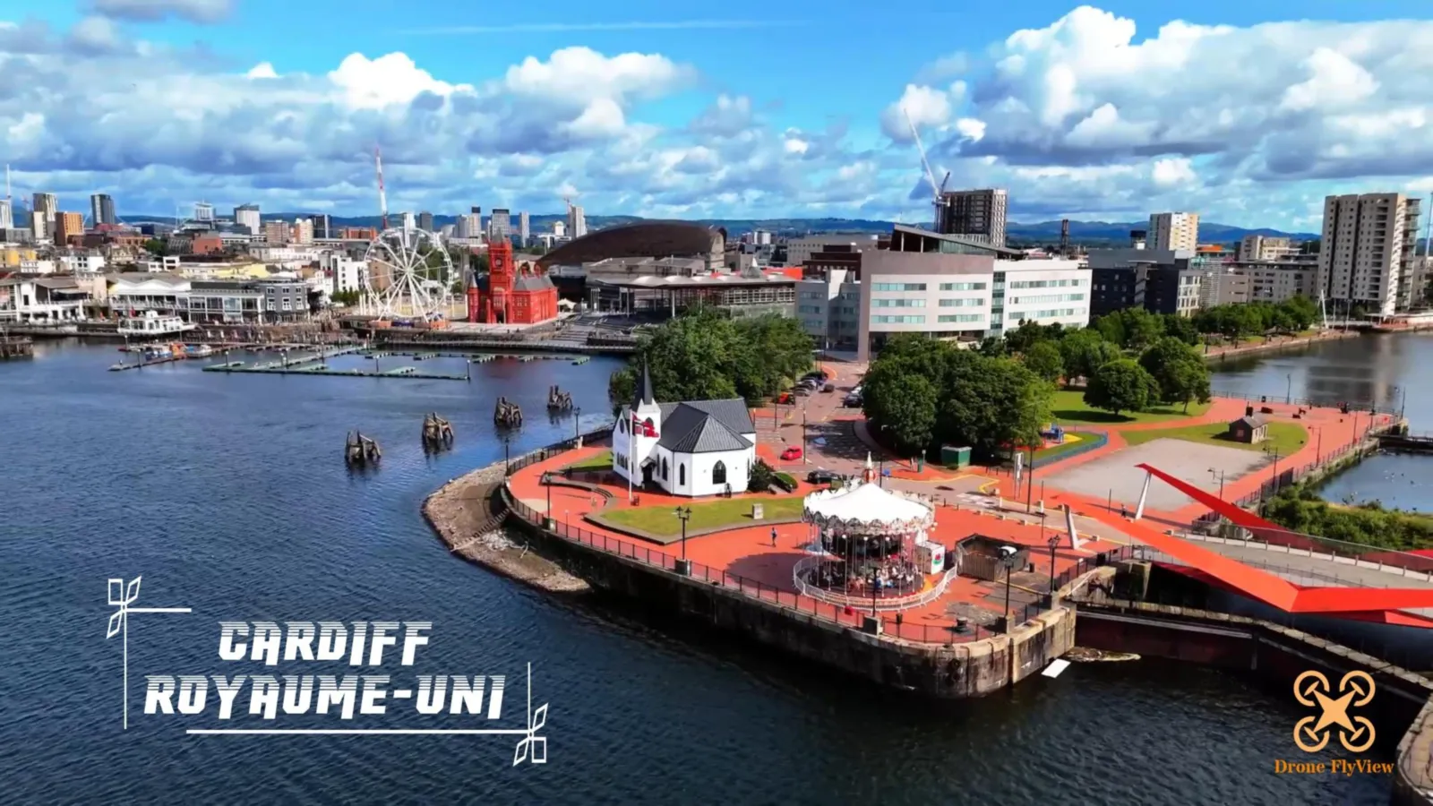 Cardiff Bay filmée en drone : l'église norvégienne et son carrousel au bord de la baie, avec le Pierhead et la grande roue en arrière-plan